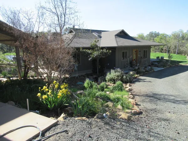 a view of a house with a yard and garden