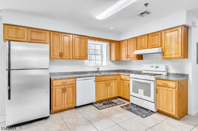 a kitchen with stainless steel appliances granite countertop a refrigerator sink and cabinets