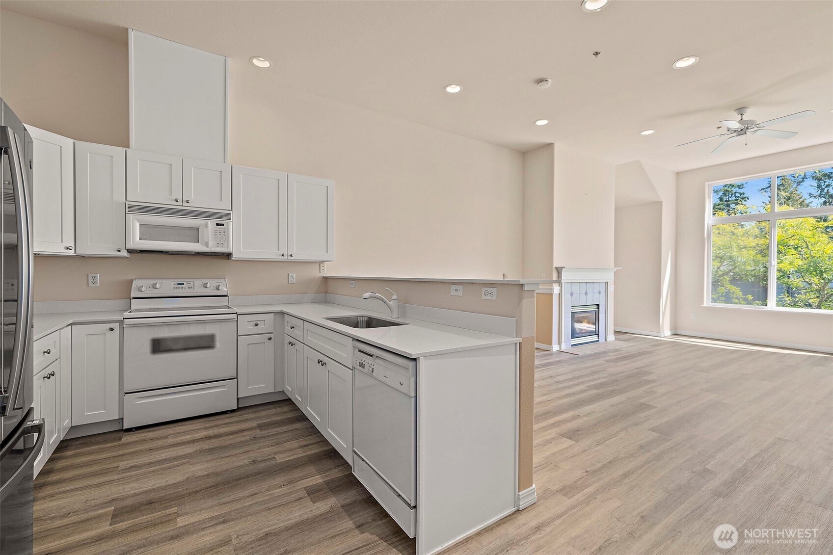 6831 Northeast 170th Street, Unit 306 Kenmore, WA 98028 - Photo 14 of 32 a kitchen with a stove a sink and a microwave
