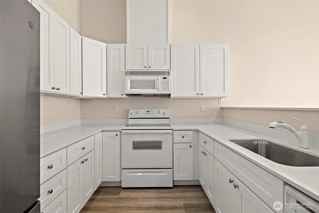 a kitchen with white cabinets and white appliances