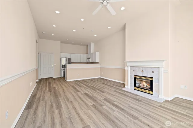 a view of kitchen and empty room with wooden floor