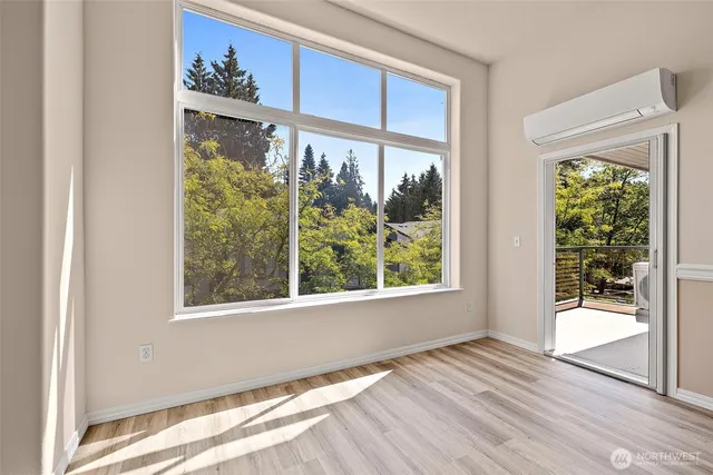 a view of an empty room with a window and wooden floor