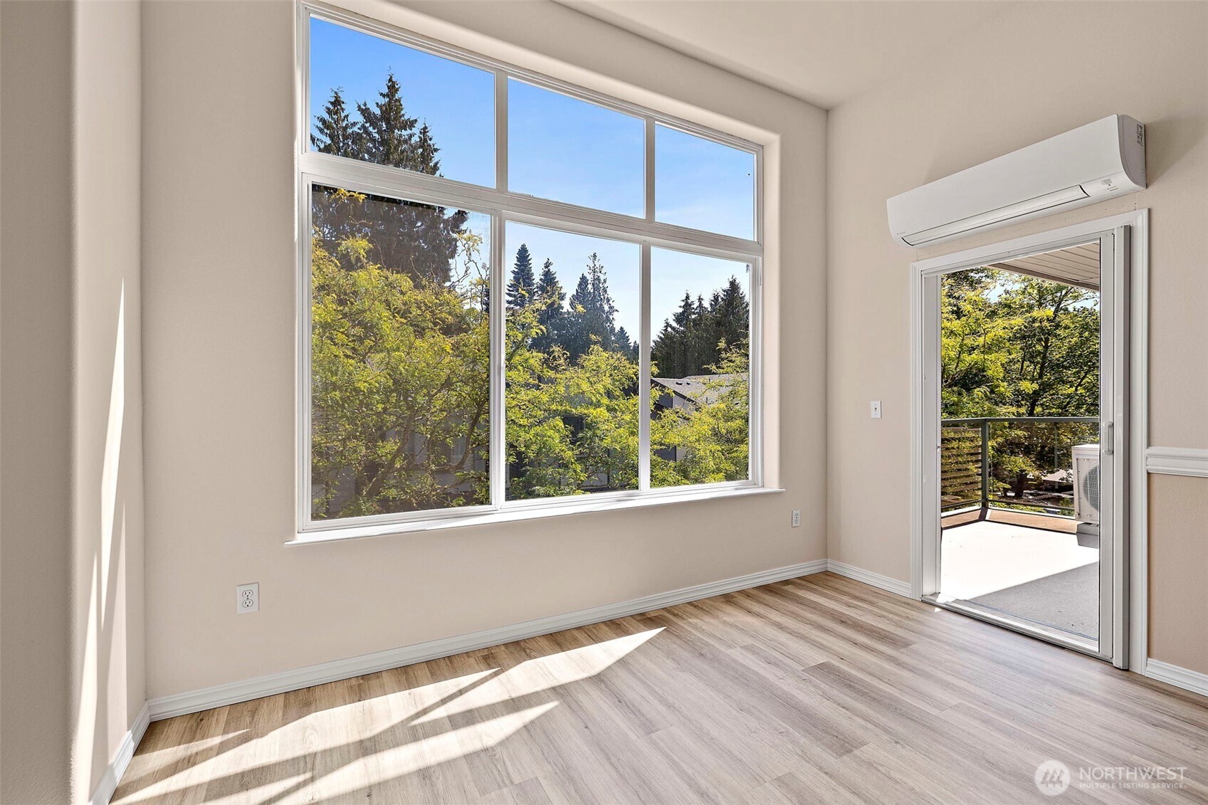 6831 Northeast 170th Street, Unit 306 Kenmore, WA 98028 - Photo 8 of 32 a view of an empty room with a window and wooden floor