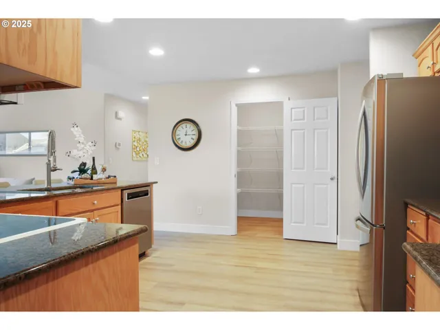 a kitchen with stainless steel appliances granite countertop a refrigerator and a sink