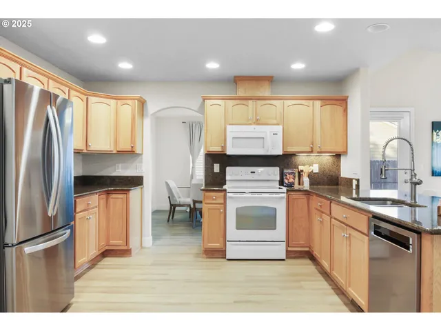 a kitchen with stainless steel appliances a refrigerator sink and cabinets