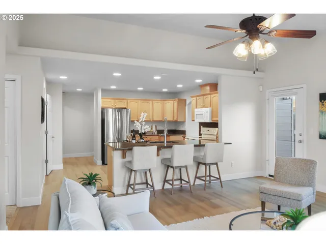 a living room with furniture and a dining table with kitchen view