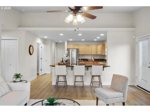 a living room with furniture kitchen view and a chandelier