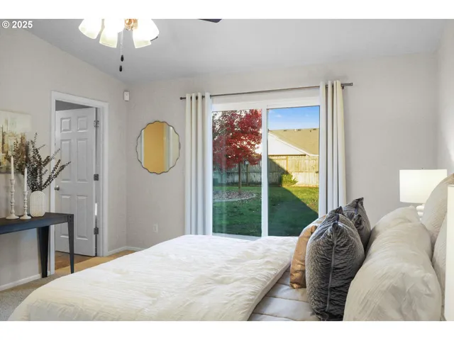 a bedroom with a bed mirror and window