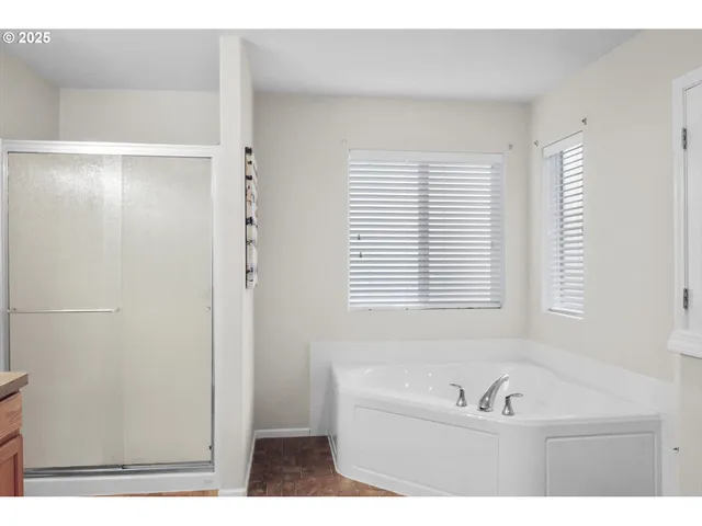 a bathroom with a tub a sink and a window