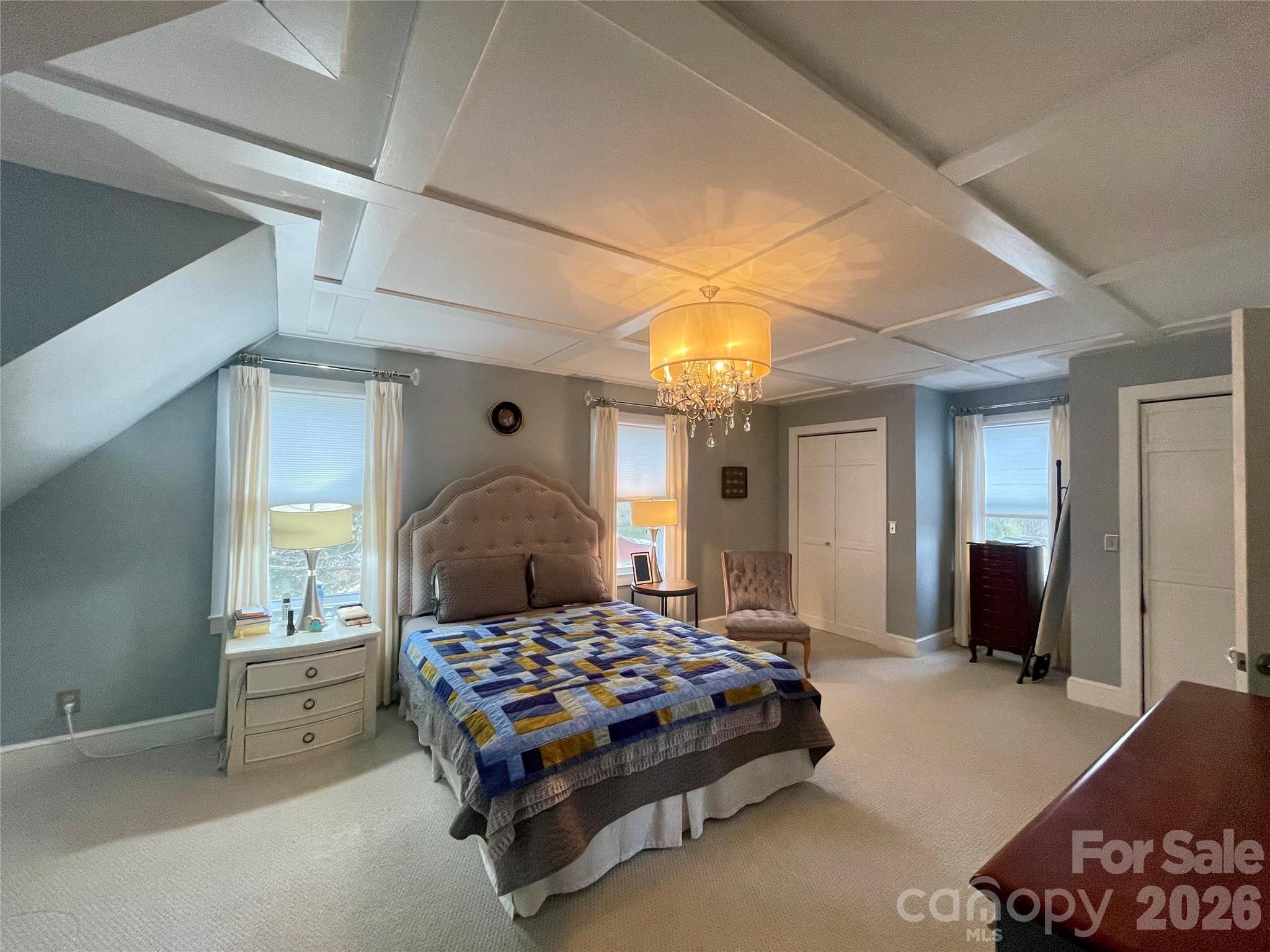 20809 Biles Road Albemarle, NC 28001 - Photo 16 of 39 a bedroom with a large bed and a chandelier