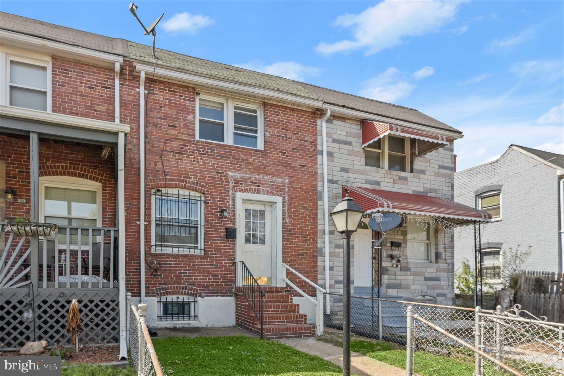 3720 St Victor Street Baltimore, MD 21225 - Photo 1 of 41 front view of a brick house with a yard