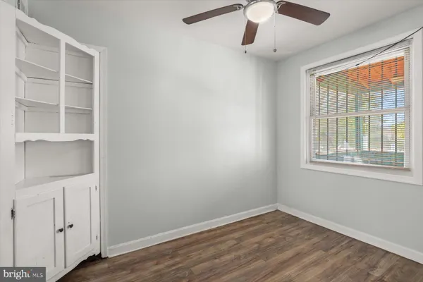 an empty room with a window and wooden floor