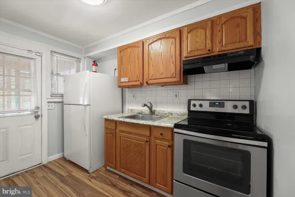 a kitchen with granite countertop a refrigerator stove and sink