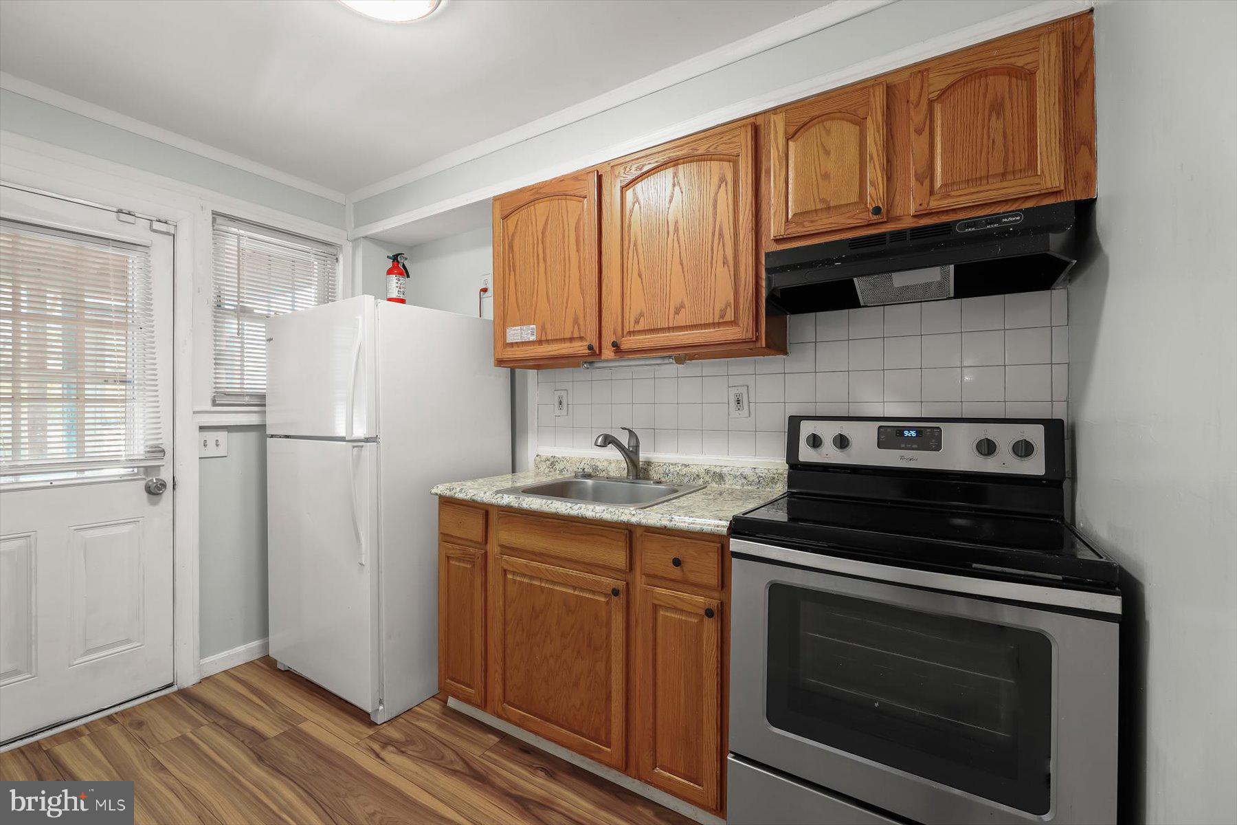 3720 St Victor Street Baltimore, MD 21225 - Photo 13 of 41 a kitchen with granite countertop a refrigerator stove and sink