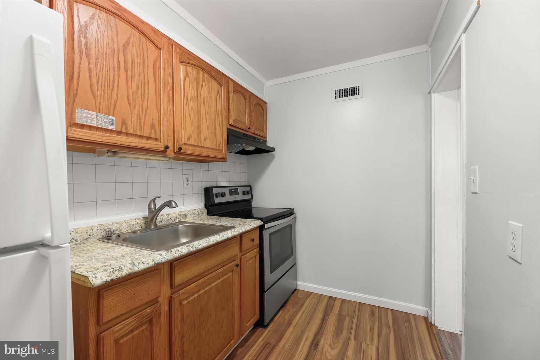 3720 St Victor Street Baltimore, MD 21225 - Photo 14 of 41 a kitchen with a sink stove and cabinets