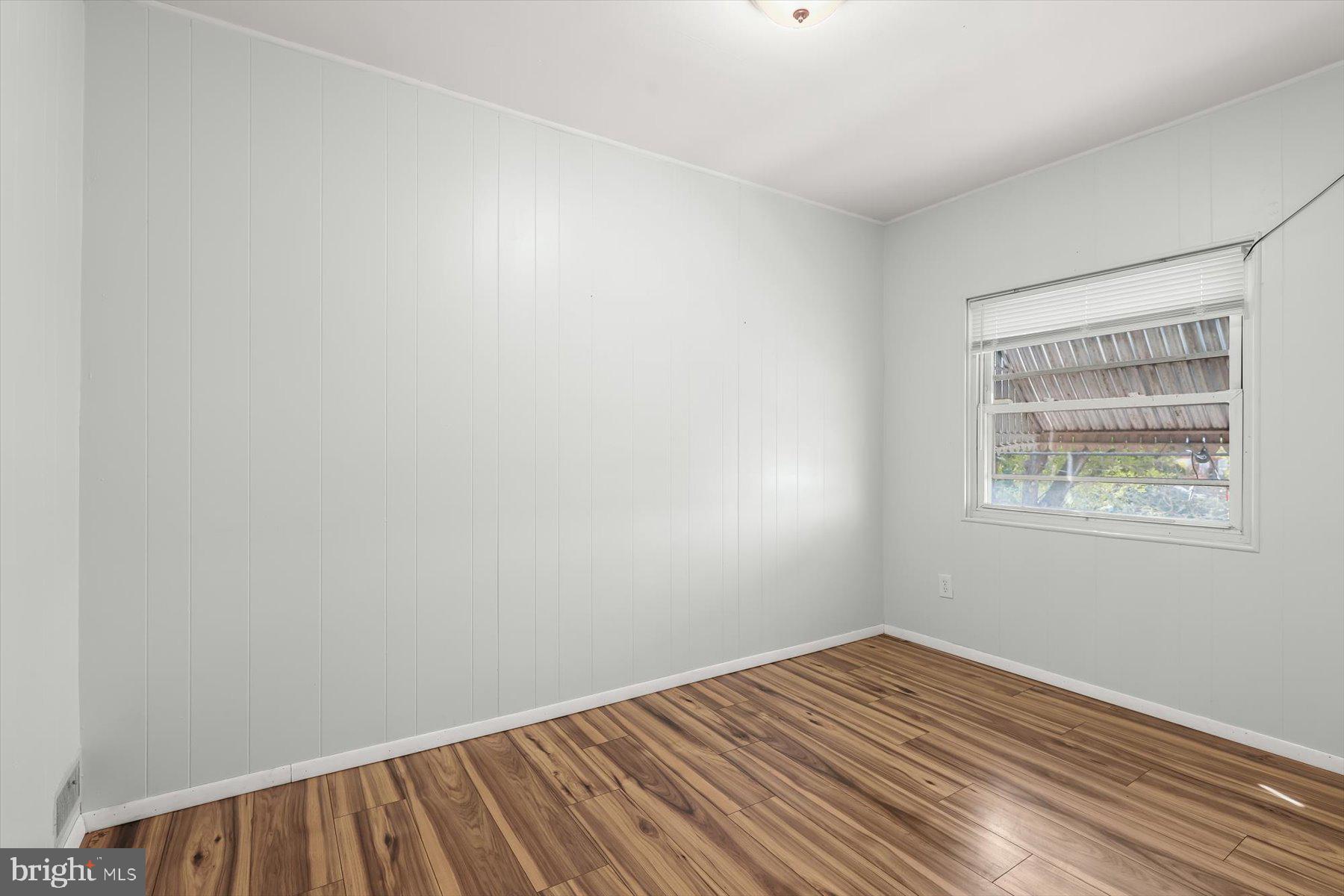 3720 St Victor Street Baltimore, MD 21225 - Photo 24 of 41 a view of an empty room with wooden floor and a window