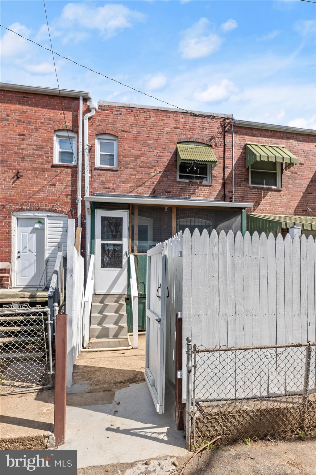 3720 St Victor Street Baltimore, MD 21225 - Photo 33 of 41 a front view of a house with a wooden fence