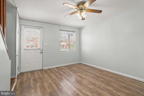 an empty room with windows and fan