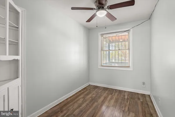 an empty room with a window and a fan