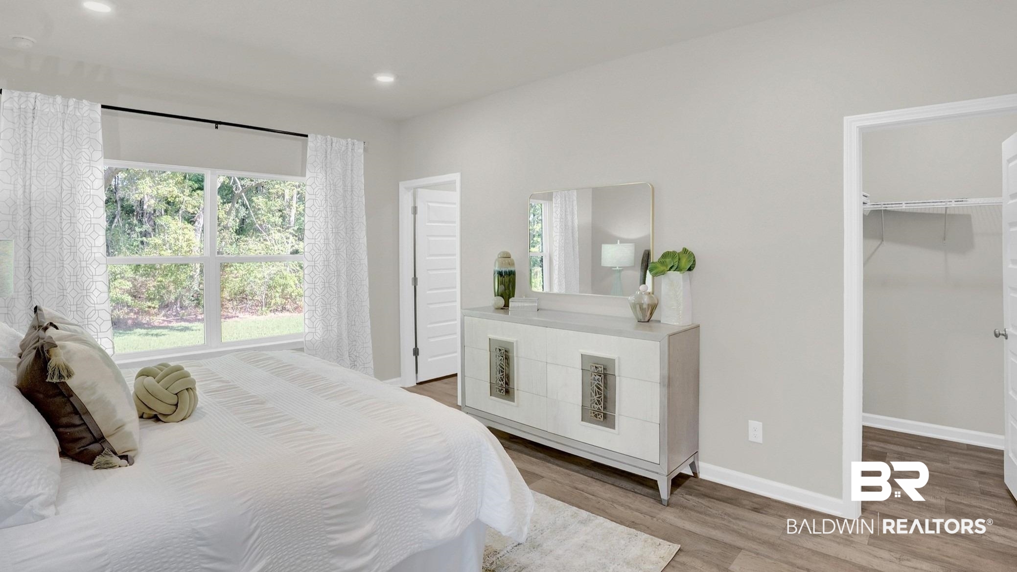 13330 Shea Circle Foley, AL 36535 - Photo 13 of 15 Spacious bedroom featuring light neutral wall paint, wood-finish flooring, a large window with ample natural light, and a dedicated closet space