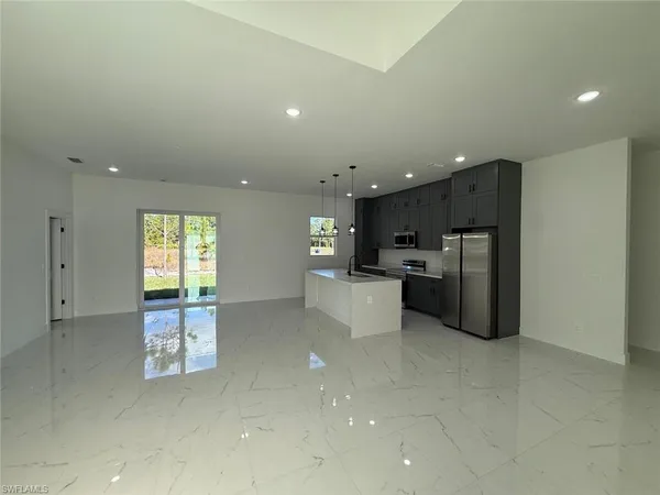a kitchen with stainless steel appliances kitchen island granite countertop a refrigerator sink and cabinets