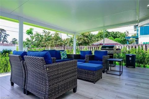 a view of a backyard with potted plants and a table and chair