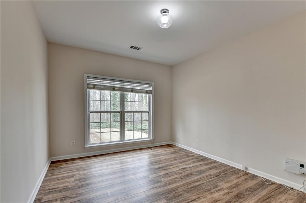 100 Hawnley Trc Northwest Suwanee, GA 30024 - Photo 32 of 58 an empty room with wooden floor and windows