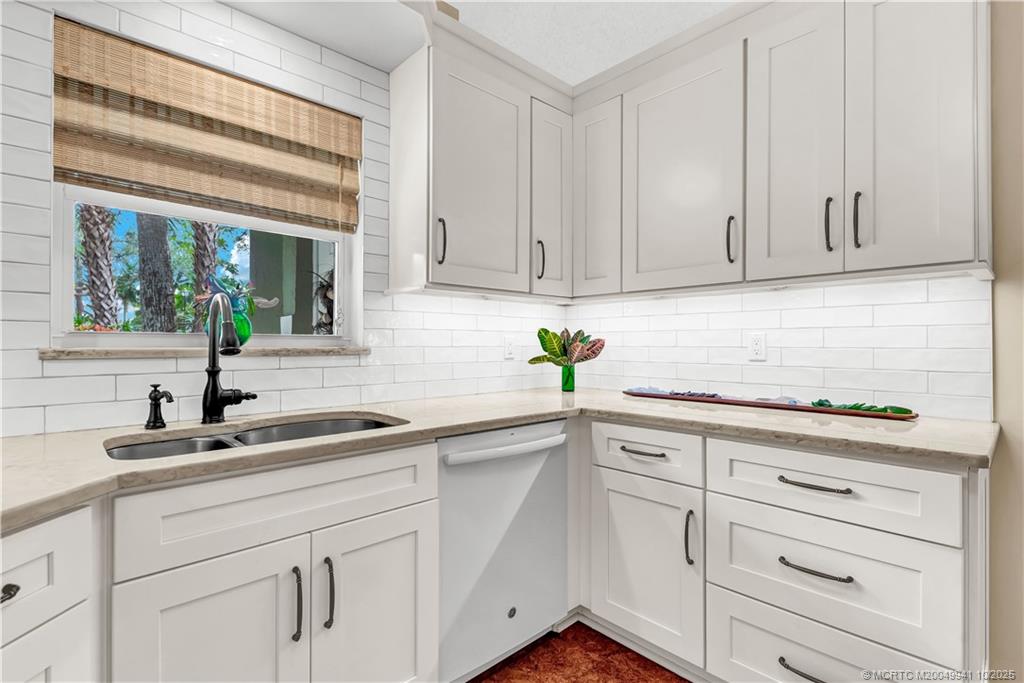 2437 Southwest Foxpoint Trail Palm City, FL 34990 - Photo 13 of 32 a kitchen with white cabinets and a window