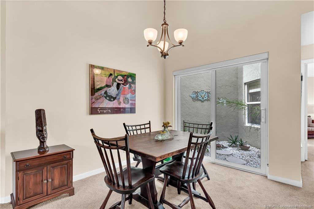 2437 Southwest Foxpoint Trail Palm City, FL 34990 - Photo 13 of 32 a view of a dining room with furniture wooden floor and a chandelier