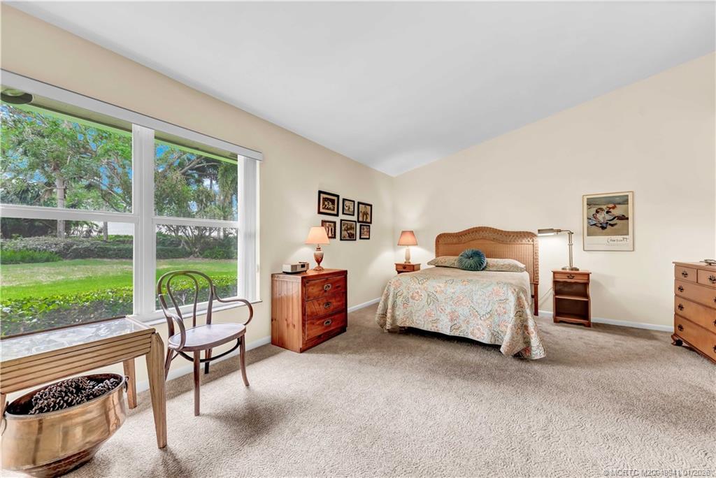 2437 Southwest Foxpoint Trail Palm City, FL 34990 - Photo 19 of 32 a bedroom with furniture and a large window