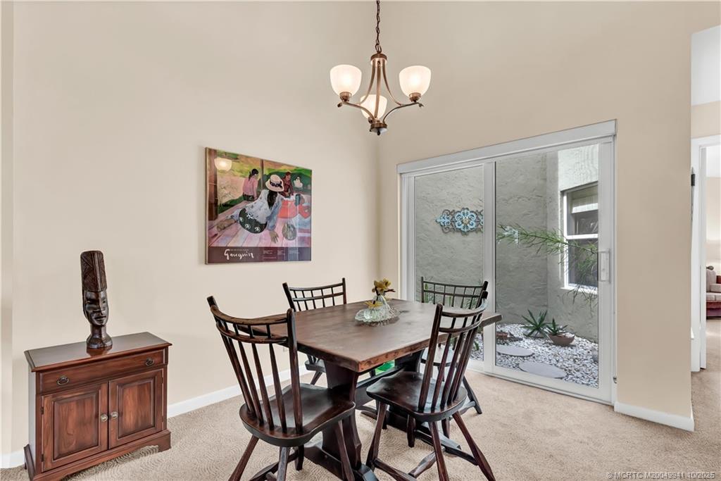 2437 Southwest Foxpoint Trail Palm City, FL 34990 - Photo 10 of 32 a view of a dining room with furniture wooden floor and a chandelier