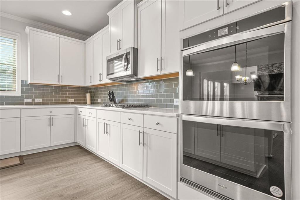 1606 Chancery Lane Lithia Springs, GA 30122 - Photo 15 of 66 a kitchen with stainless steel appliances white cabinets and wooden floors