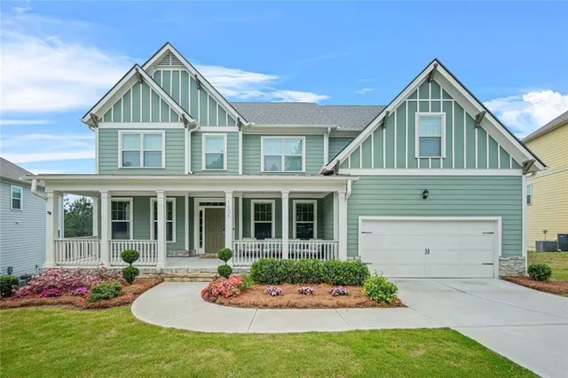a front view of a house with a yard and potted plants
