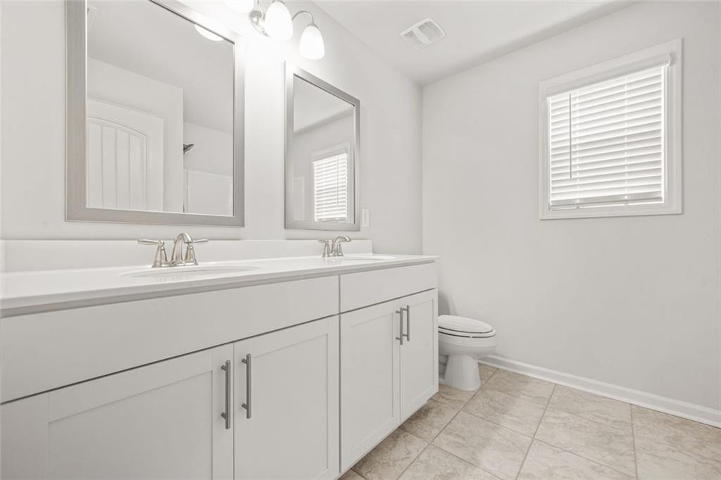 1606 Chancery Lane Lithia Springs, GA 30122 - Photo 25 of 66 a bathroom with a double vanity sink a toilet and a mirror