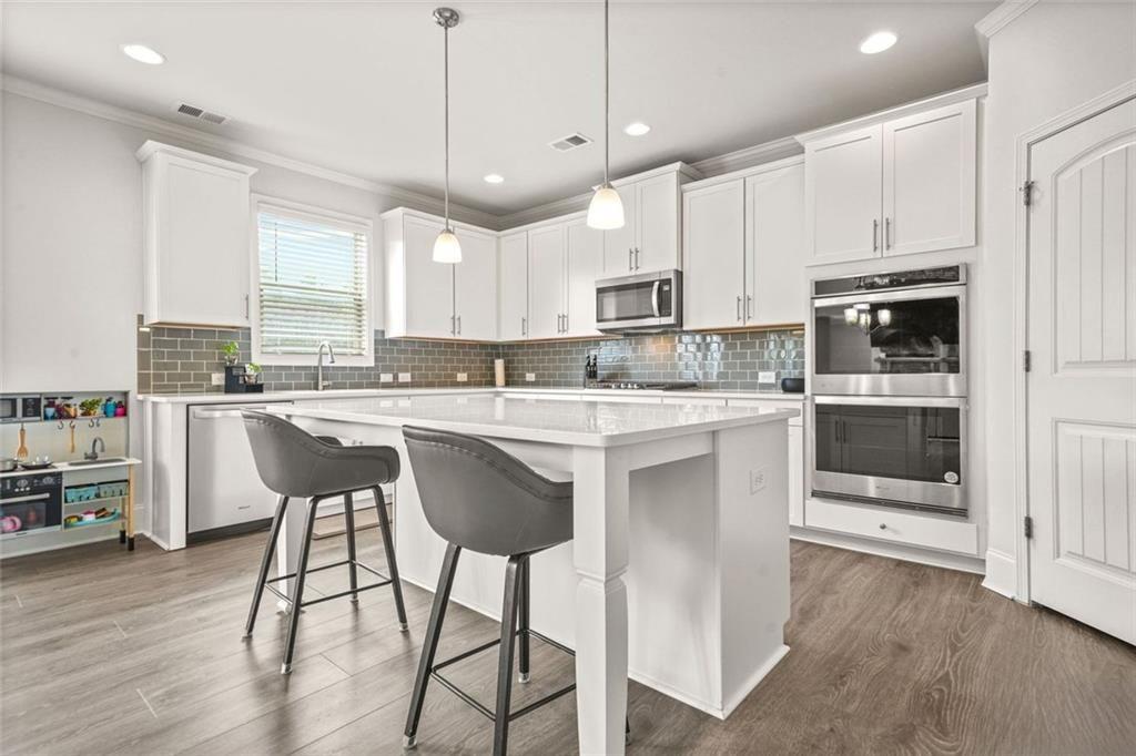 1606 Chancery Lane Lithia Springs, GA 30122 - Photo 39 of 66 a kitchen with stainless steel appliances kitchen island a white cabinets and wooden floor
