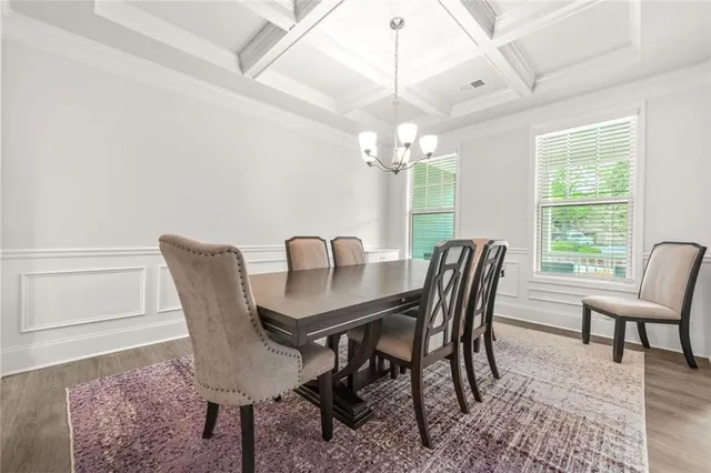 a view of a dining room with furniture a chandelier and wooden floor