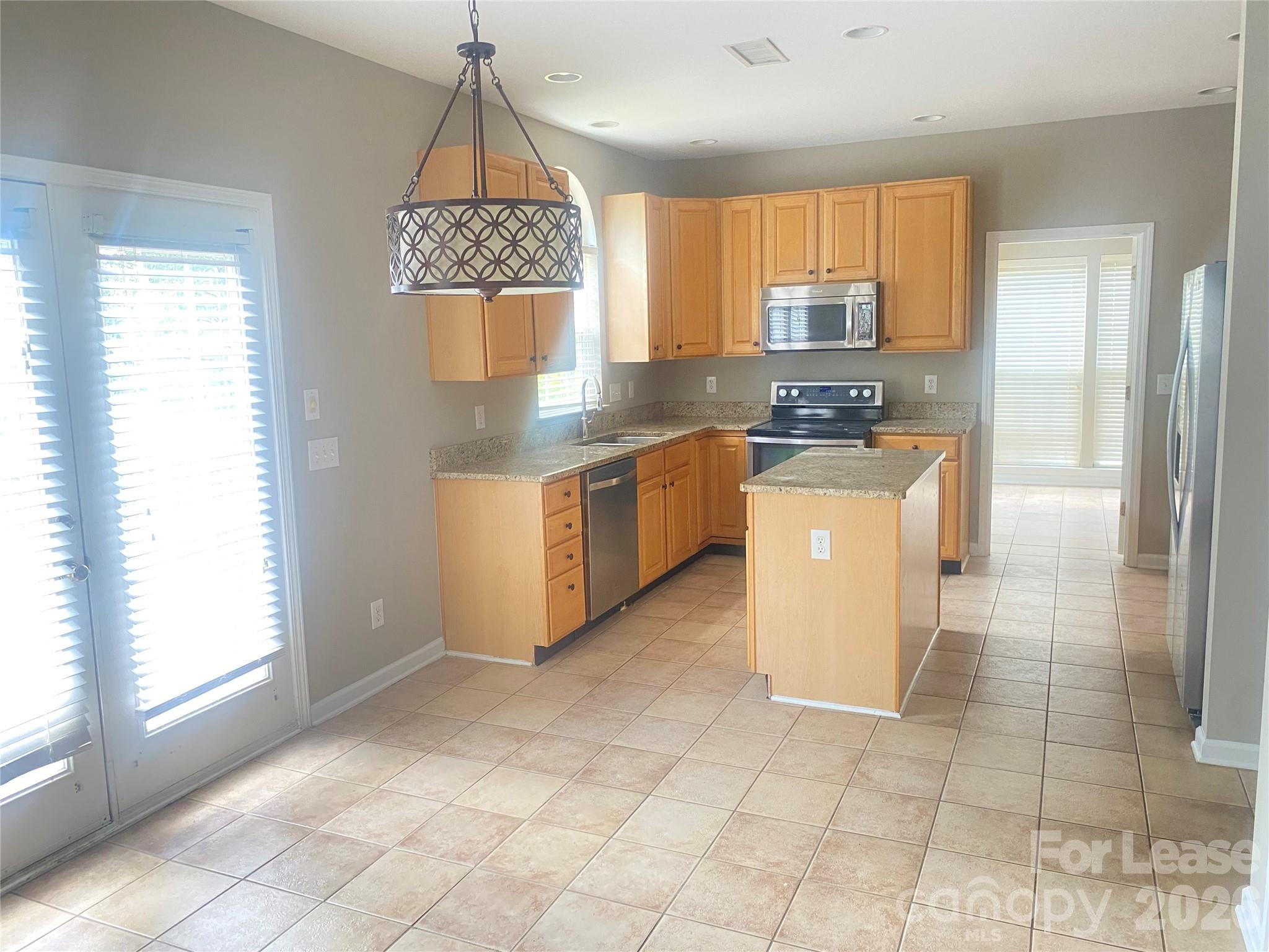 13518 Northbourne Road Huntersville, NC 28078 - Photo 3 of 15 a kitchen with granite countertop a stove a sink and a refrigerator