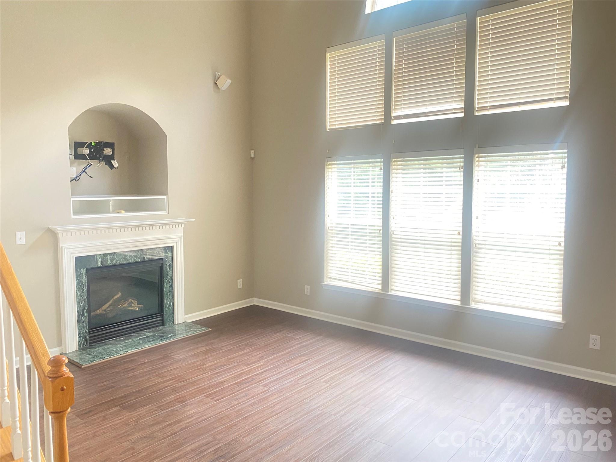 13518 Northbourne Road Huntersville, NC 28078 - Photo 4 of 15 an empty room with wooden floor fireplace and windows