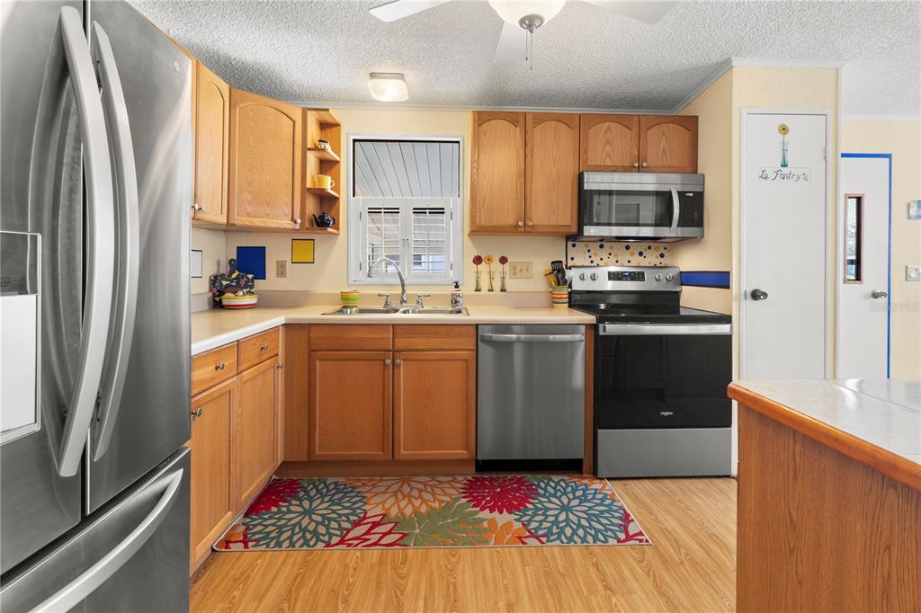 148 Nightingale Circle Ellenton, FL 34222 - Photo 15 of 47 a kitchen with stainless steel appliances a sink a stove a refrigerator cabinets and a window