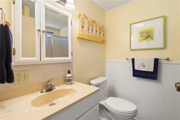 a bathroom with a sink mirror vanity and toilet