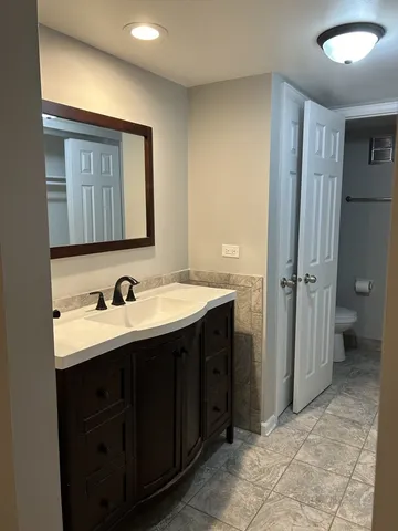 a bathroom with a sink and mirror with toilet