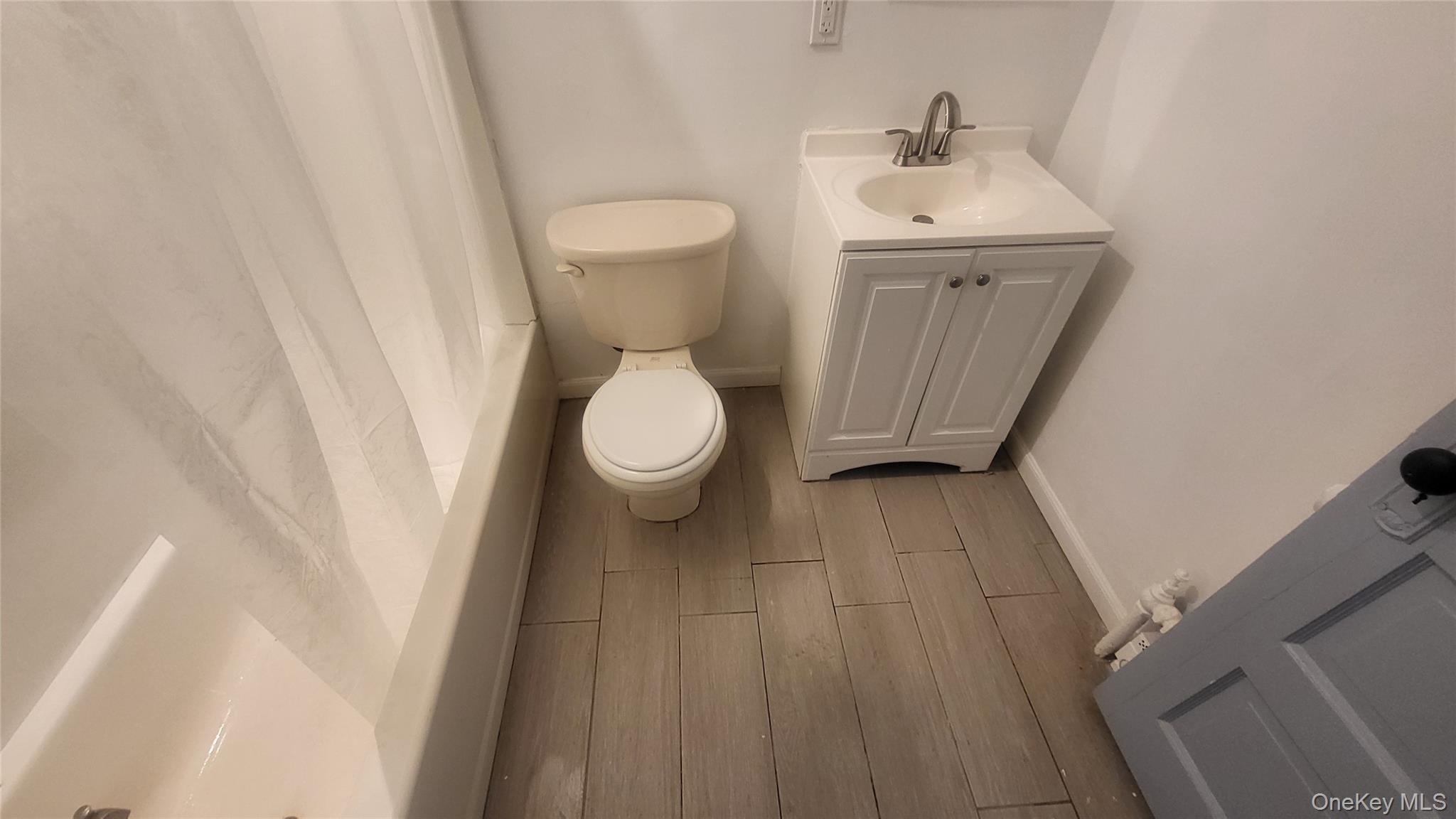 76 South Hamilton Street, Unit 2 Poughkeepsie, NY 12601 - Photo 19 of 19 a bathroom with a sink a toilet and a mirror