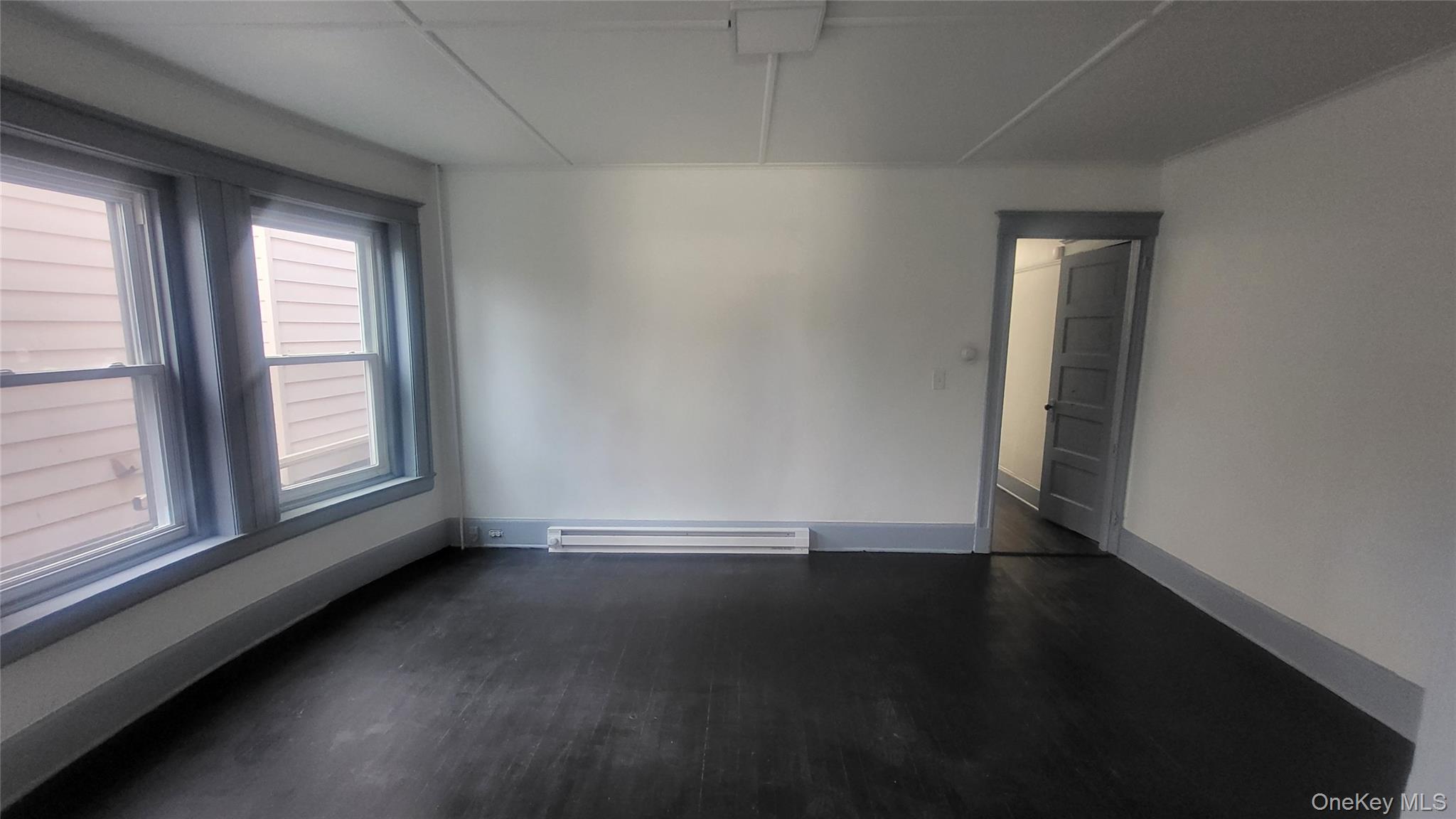 76 South Hamilton Street, Unit 2 Poughkeepsie, NY 12601 - Photo 9 of 19 an empty room with wooden floor and windows