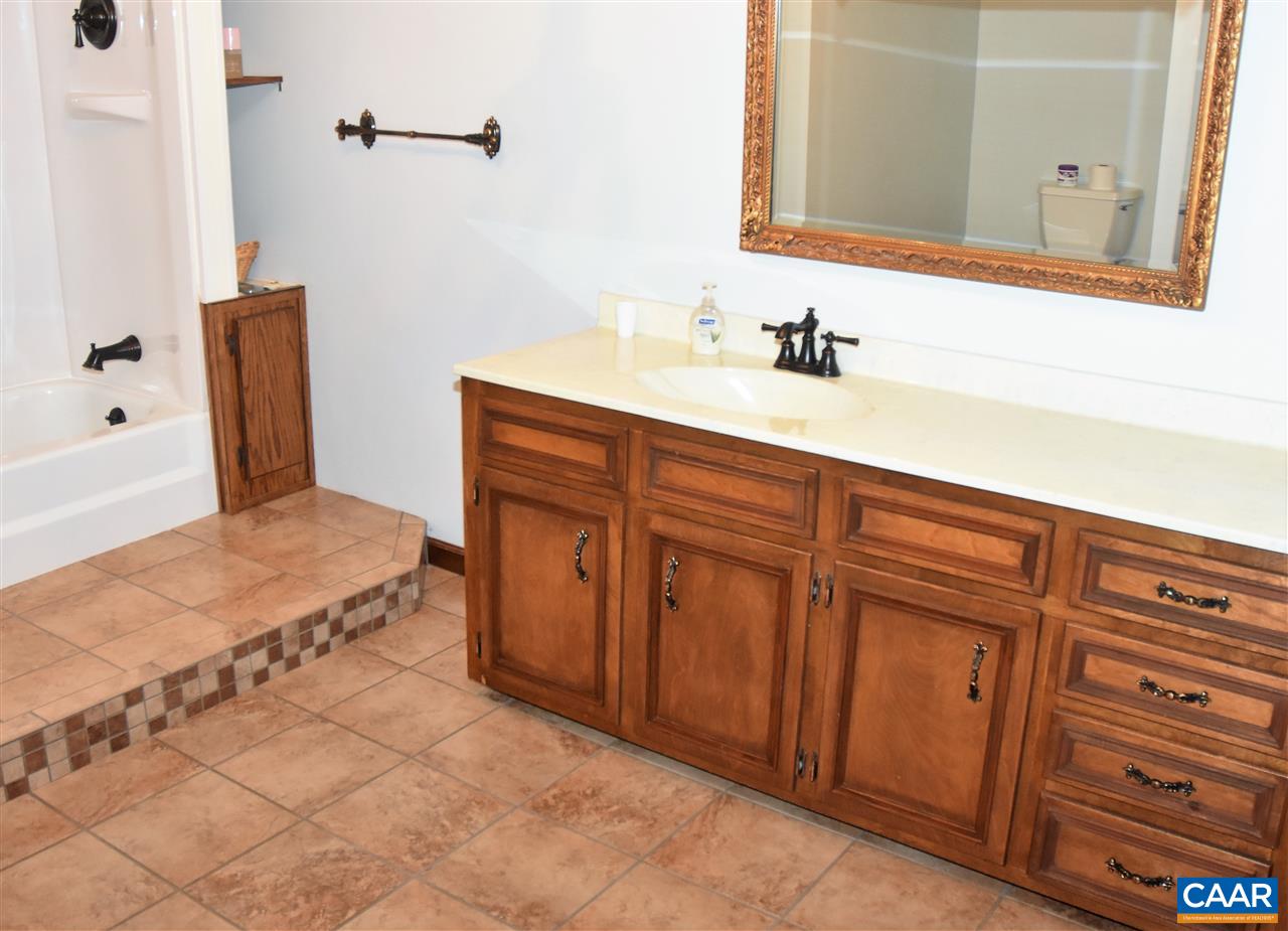 4193 Celt Road Stanardsville, VA 22973 - Photo 21 of 35 a bathroom with a tub sink and mirror