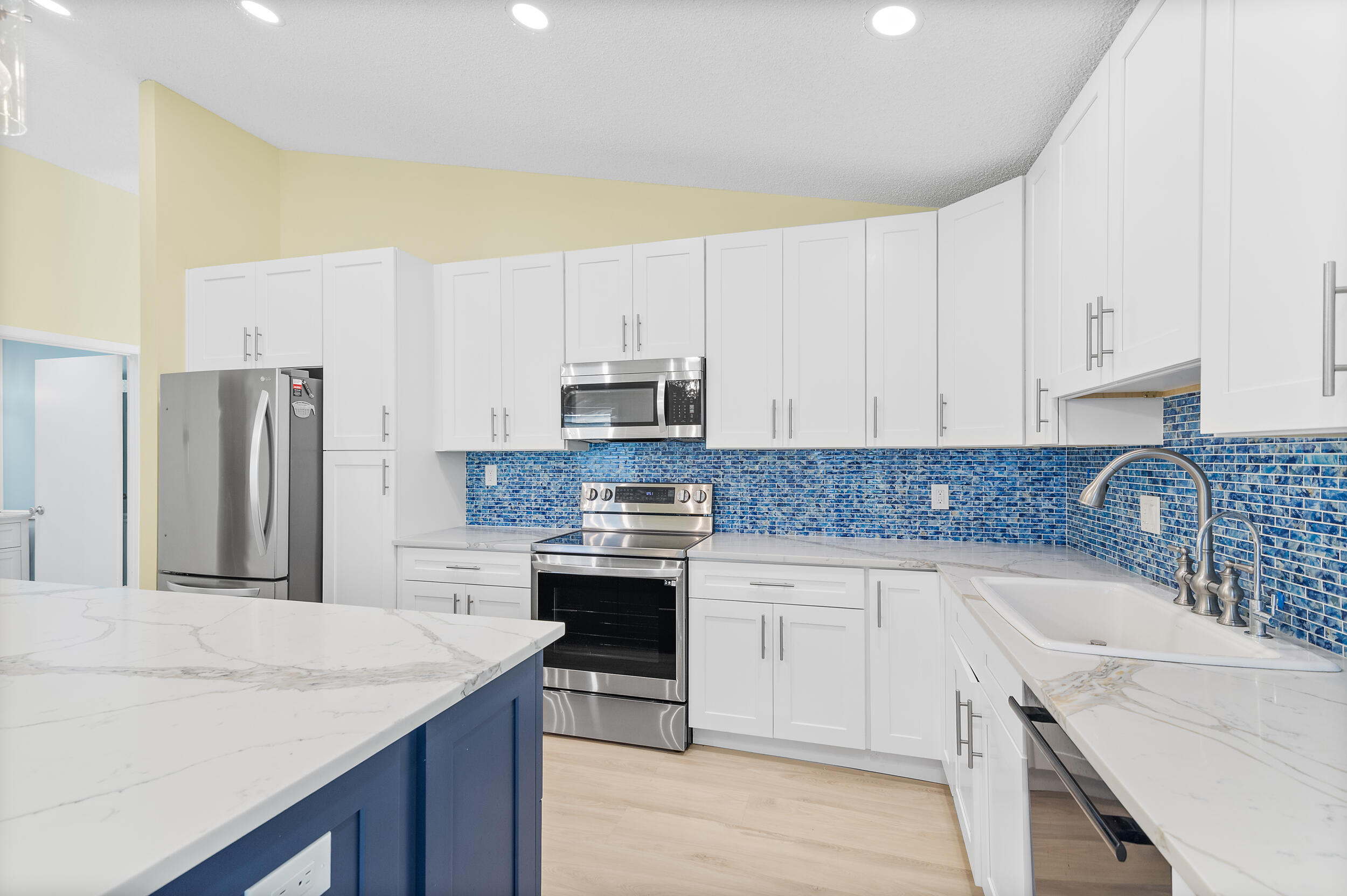 2685 Riviera Drive Delray Beach, FL 33445 - Photo 17 of 48 a kitchen with granite countertop a sink stove and refrigerator