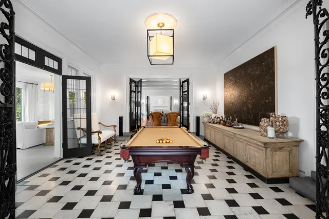 a room with a black white checkered floor with a gaming machine and dining table