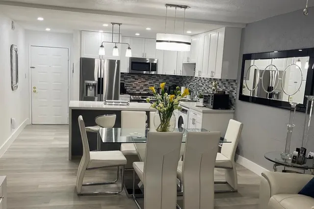 a dining room with furniture and view of kitchen