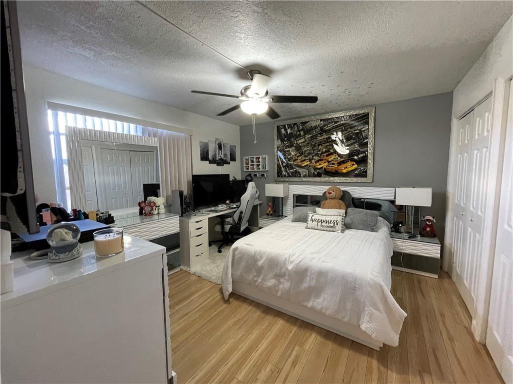 6950 Northwest 186th Street, Unit 2510 Hialeah, FL 33015 - Photo 14 of 19 a living room with furniture a flat screen tv and a chandelier