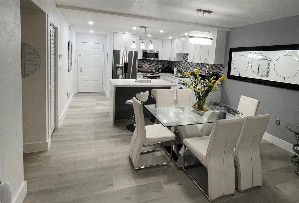 6950 Northwest 186th Street, Unit 2510 Hialeah, FL 33015 - Photo 4 of 19 a dining room with stainless steel appliances kitchen island granite countertop furniture and a view of kitchen