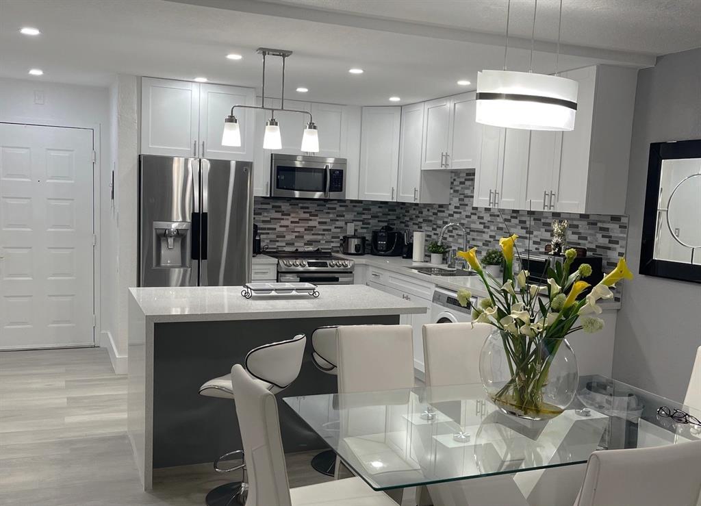 6950 Northwest 186th Street, Unit 2510 Hialeah, FL 33015 - Photo 5 of 19 a kitchen with counter and chairs in it